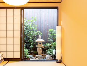 Experience serene tranquility in a traditional Japanese-inspired space with a sliding shoji screen door and a peaceful garden area.