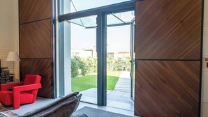 A modern interior with a large glass door leading to a garden.