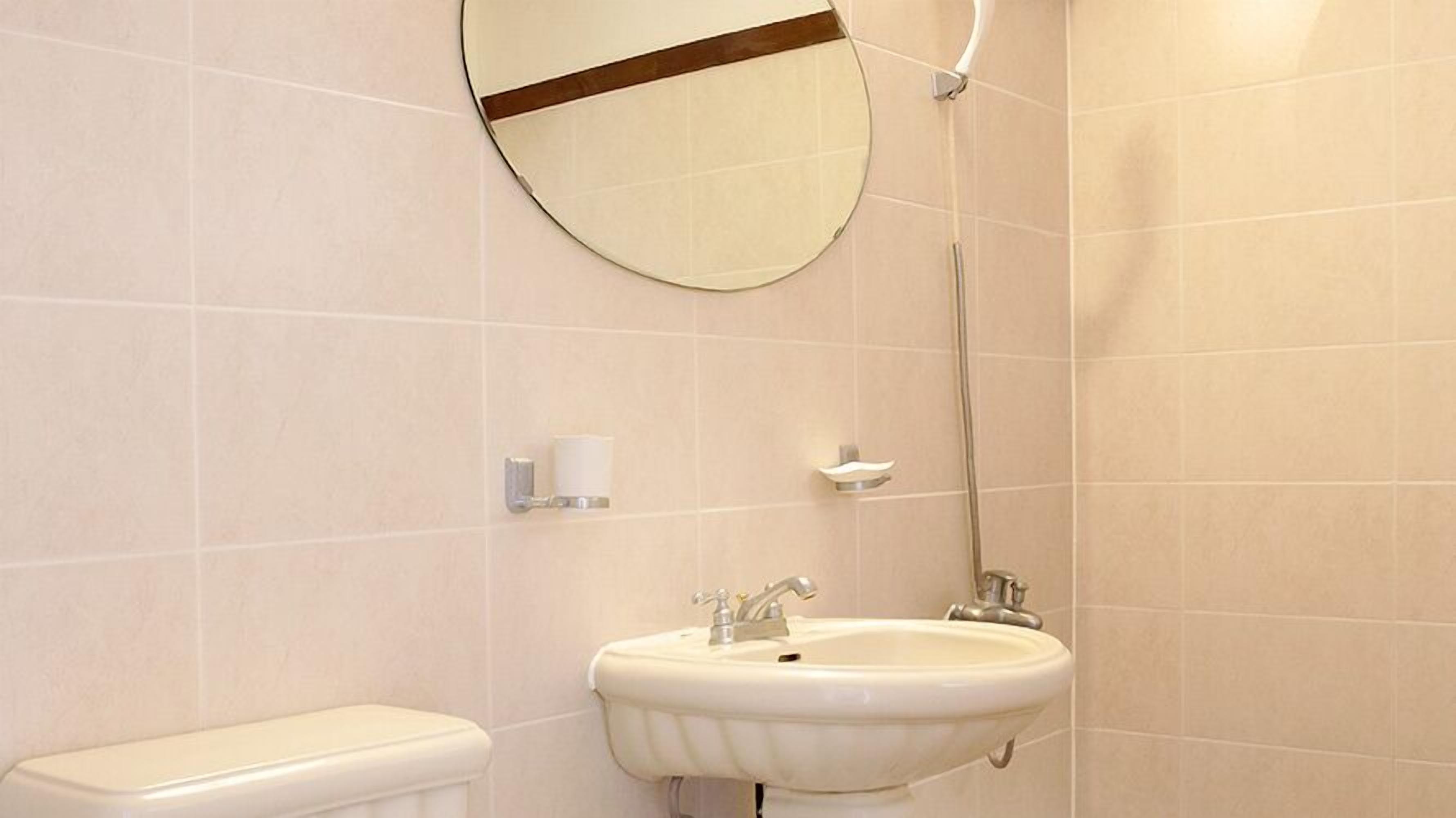 Baño con inodoro, lavamanos y espejo.