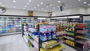 A grocery store with refrigerated sections on the left and a variety of packaged goods on the right.