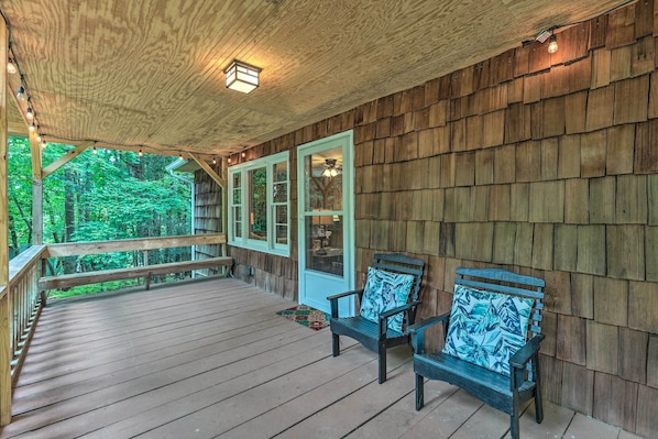 A wooden deck with two chairs and a bench, surrounded by wooden walls and a view of greenery. - Near Hiking: Roaring Gap Retreat w/ Fire Pit! (Roaring Gap)