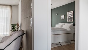 A modern bedroom with a bed, a bedside table, and a window with curtains. - CLOUD No7 STUDIOS (Tuebingen)