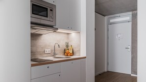 A modern kitchen with a stainless steel microwave, a sink, and a wooden countertop. - CLOUD No7 STUDIOS (Tuebingen)