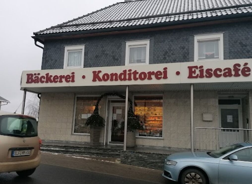 Een gebouw met een bord waarop staat: Bäckerei · Konditorei · Eiscafé.
