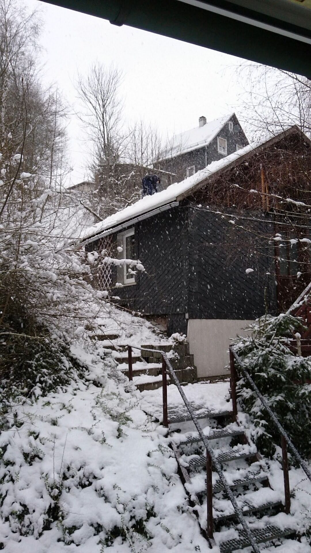 Ein verschneiter Außenbereich mit einer Treppe, die zu einem Gebäude führt.