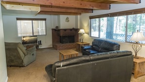 A cozy living room with a fireplace, leather sofa, and a television.