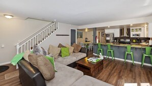 Un salon moderne avec un canapé, une table basse et un escalier.