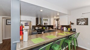 Une cuisine moderne dotée d’un îlot central, de tabourets de bar et d’une pancarte de bienvenue.