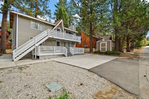 A two-story house with a front porch and a staircase leading to the upper level.