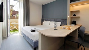 A modern hotel room with a bed, desk, and a view of the outdoors. - Vico Fashion District (Milan)