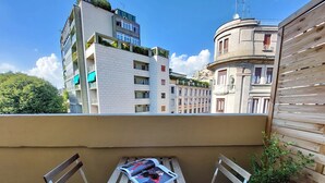 A balcony with a table and chairs, a magazine, and a pair of sunglasses. - Vico Fashion District (Milan)