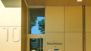 A yellow building with a glass door entrance, a sign reading "limehome", and a small display board with information. - Limehome Dresden Wallstraße (Dresden)