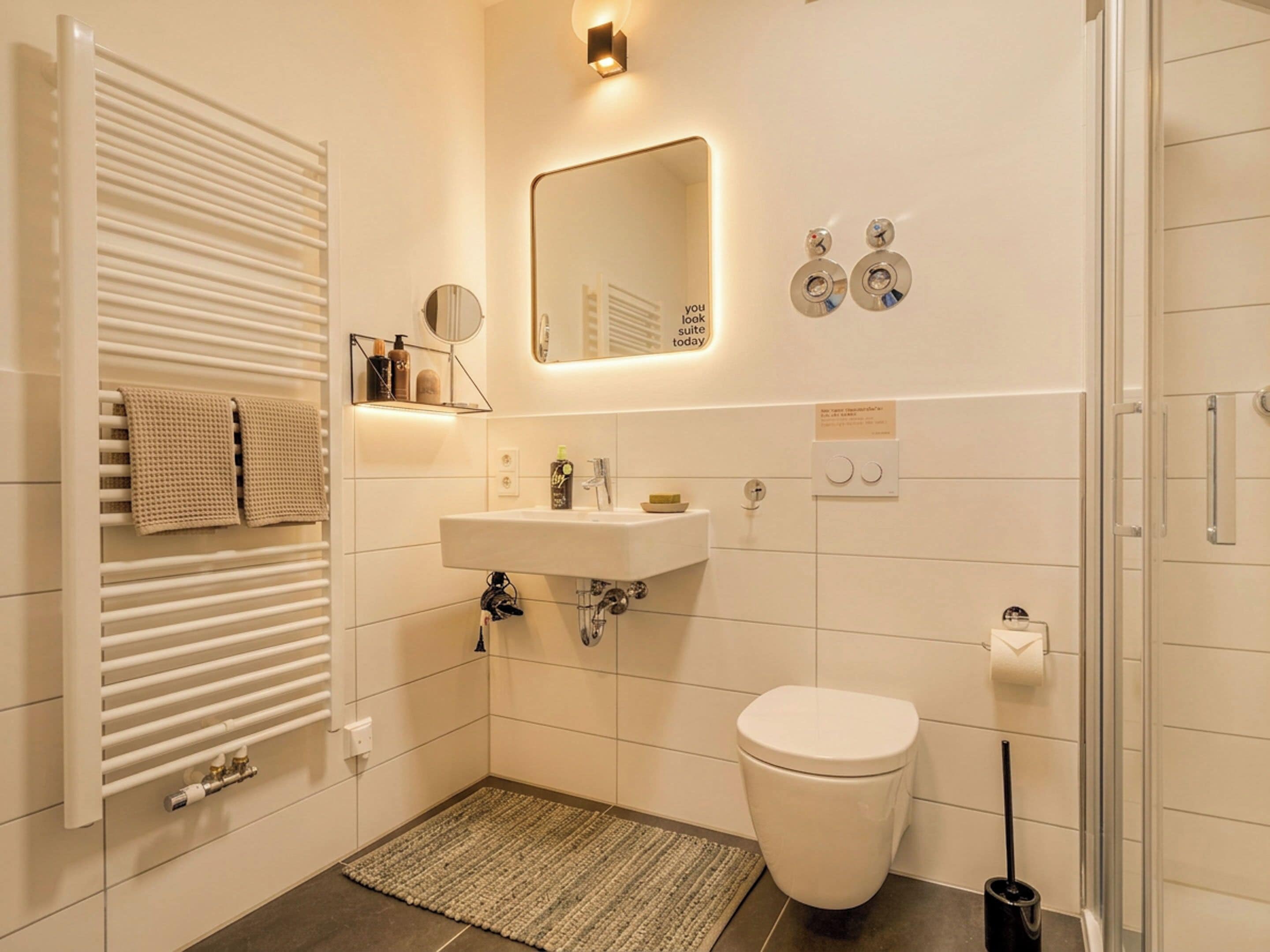 Ein modernes Badezimmer mit Waschbecken, Toilette und Handtuchhalter.