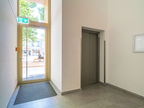 En hall med en dörr, en ventilationsöppning och ett fönster med utsikt över omgivningen.