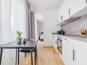 Suite L with balcony & courtyard view | Yksityinen keittiö | Jääkaappi, kahvin-/teenkeitin, ruokailupöytä