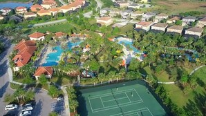 Ein Luftbild eines Wohngebiets mit Häusern, einem Schwimmbad und Tennisplätzen.