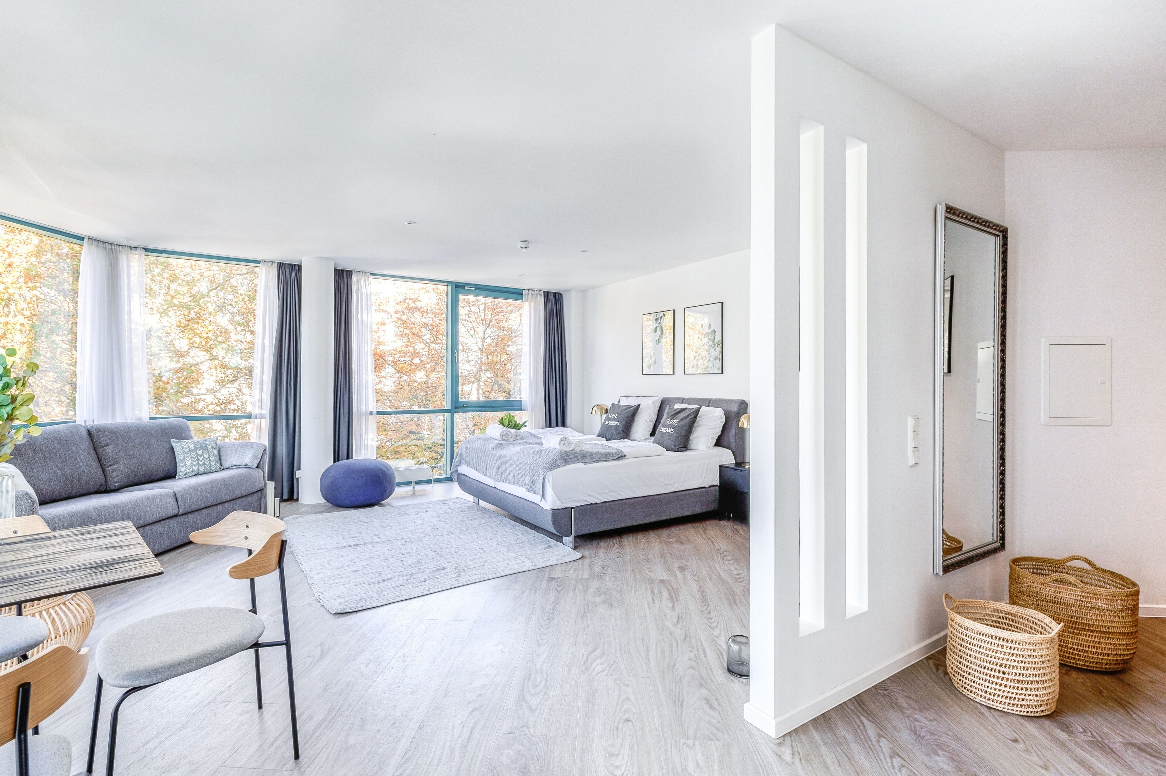 A modern bedroom with a bed, sofa, and dining area.