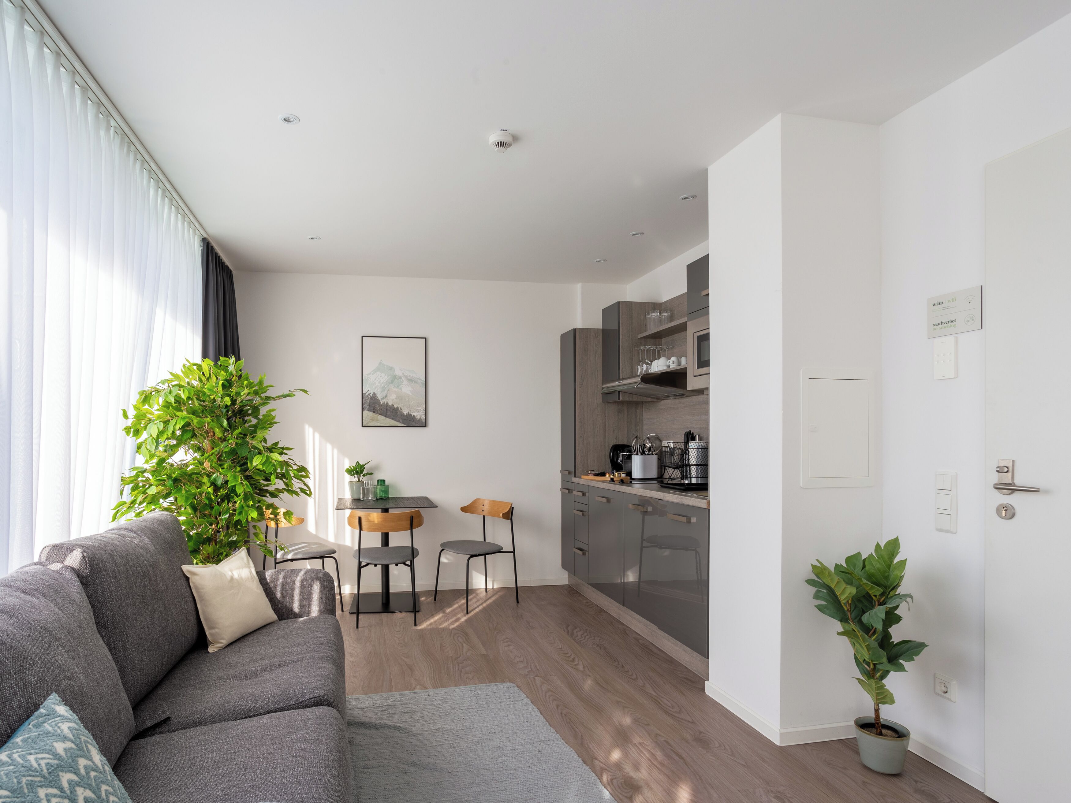 A modern apartment with a living room, kitchen, and dining area.