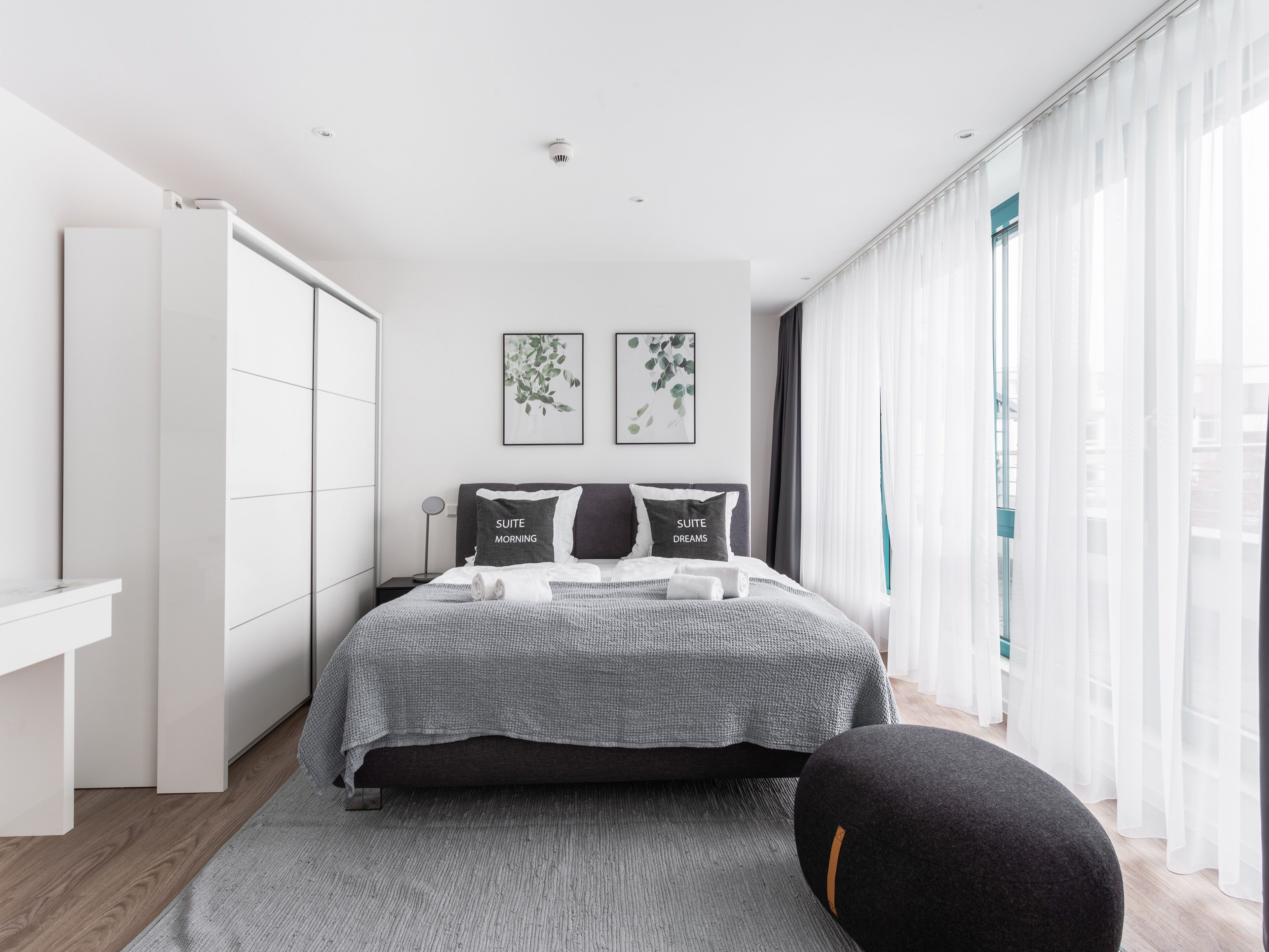 Un dormitorio moderno con cama, mesita de noche y armario.