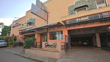A building with a sign reading "Grace Residence Hall" and a covered entrance.