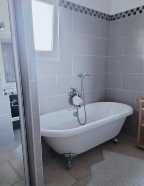 A bathroom with a freestanding bathtub, a showerhead, and a tiled floor. - House in the Aix countryside (Mimet)