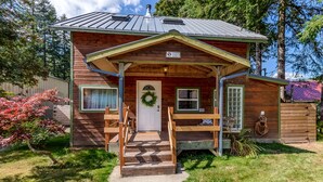 Eine Holzhütte mit Veranda, einer Tür mit Kranz und einem kleinen Fenster.