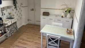 Une cuisine équipée d’un évier, d’un plan de travail et d’une table à manger avec des chaises.
