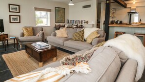 A living room with a sofa set, a coffee table, and a bookshelf. - Waterside (Ravenglass)