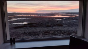 A window view of a natural landscape with a sunset. - Waterside (Ravenglass)