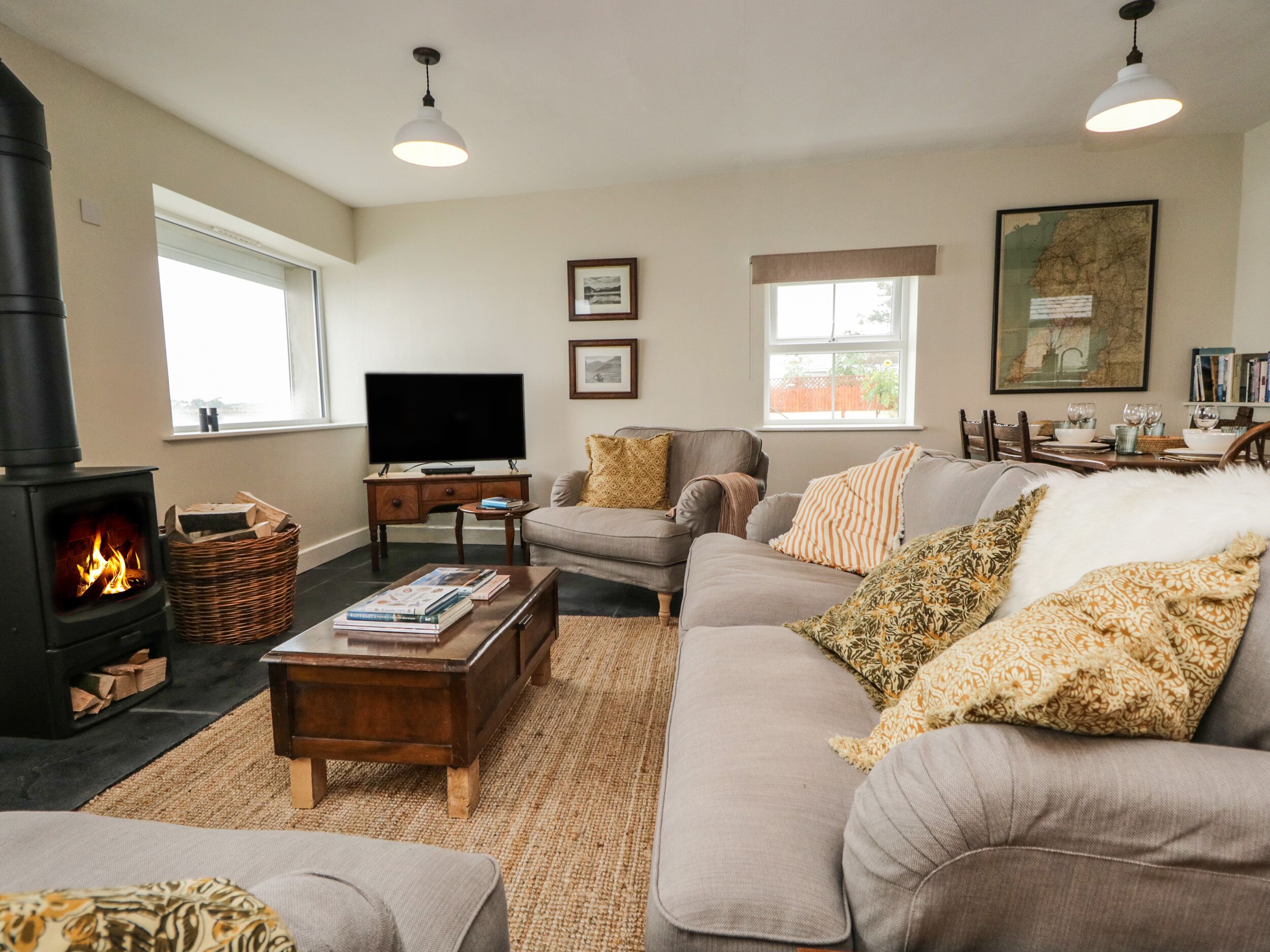 A cozy living room with a fireplace, sofa, and television.