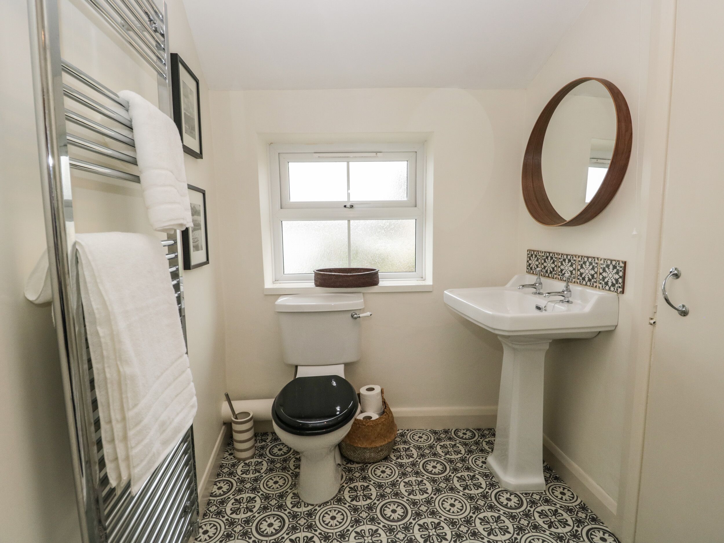 Une salle de bain avec des toilettes, un lavabo et une fenêtre.