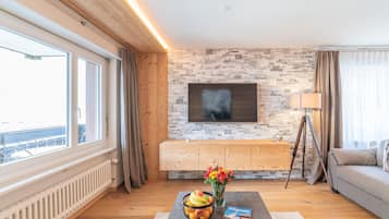 Comfort appartement | Woonruimte | Een 108-inch flatscreentelevisie met kabelzenders en een televisie