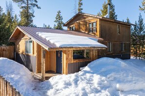 A wooden cabin with a metal roof, surrounded by snow and trees. - Great Backyard with Firepit, Wood Burning Stove & Pet Friendly! (Grand Lake)