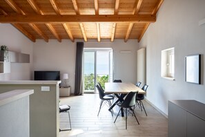 Un intérieur moderne comprenant un coin repas, un téléviseur et un balcon avec vue.