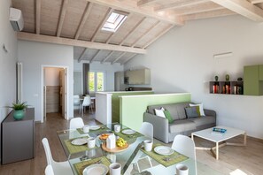 A modern interior with a dining area, a kitchen, and a living space.