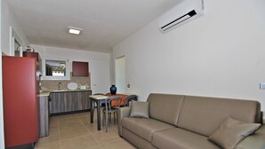 A compact living space with a kitchenette, a sofa, and a dining area.