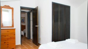 Une chambre à coucher avec un lit, une commode et une armoire.