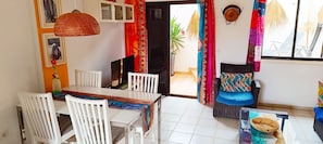 Un espace repas comprenant une table et des chaises, un tĂ©lĂ©viseur et une vue sur lâextĂ©rieur.