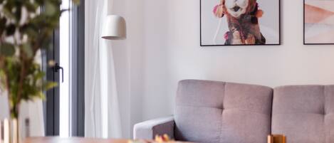 A modern living room with a grey sofa, a coffee table, and a framed picture on the wall.
