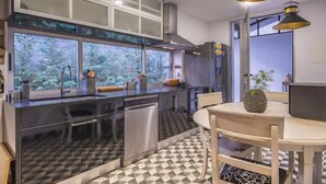 Una cocina moderna con un ventanal grande, un comedor con mesa y sillas, y un suelo con diseño.