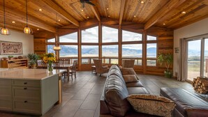 Amplia sala de estar con un sofá grande, una mesa de comedor y una zona de cocina con barra.