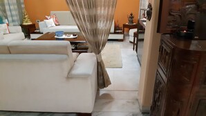 Un salon avec un canapé blanc, une table basse et une statue décorative.