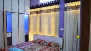 Une chambre à coucher avec un lit, des rideaux et une armoire.