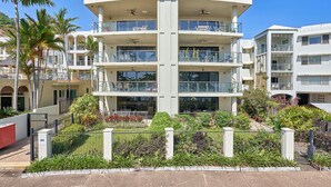 Un hôtel à plusieurs étages doté de balcons, d’une cour intérieure et entouré de verdure.