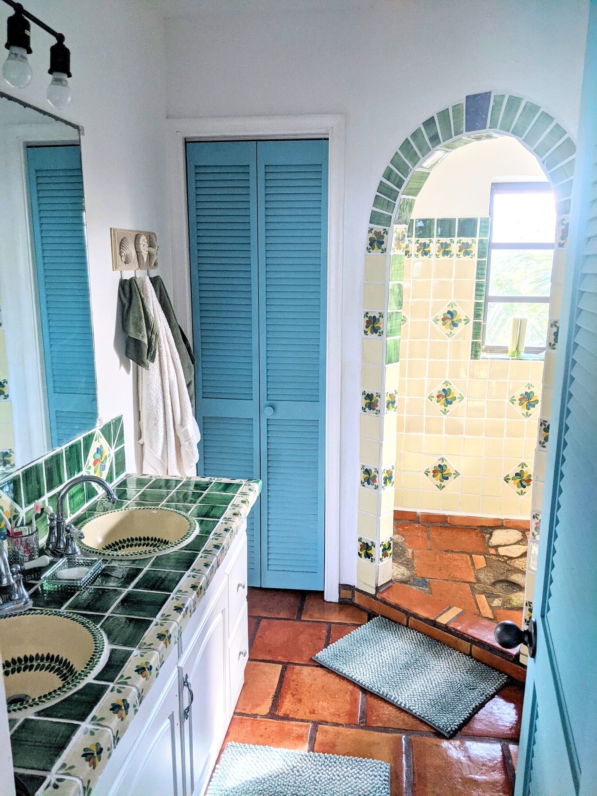 Un baño con dos lavamanos, un espejo y una zona de ducha.