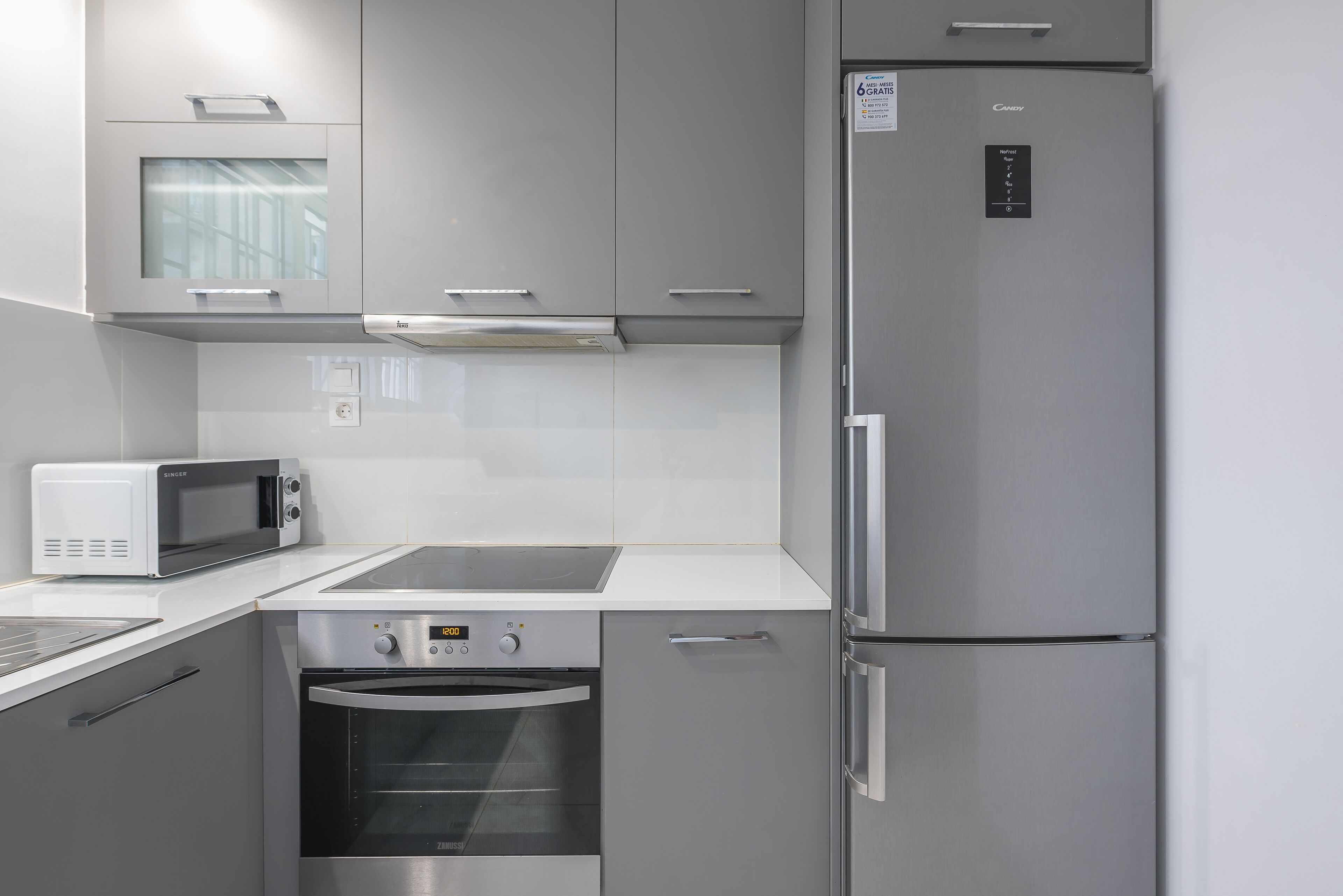 A compact kitchen with a built-in microwave, oven, and refrigerator.