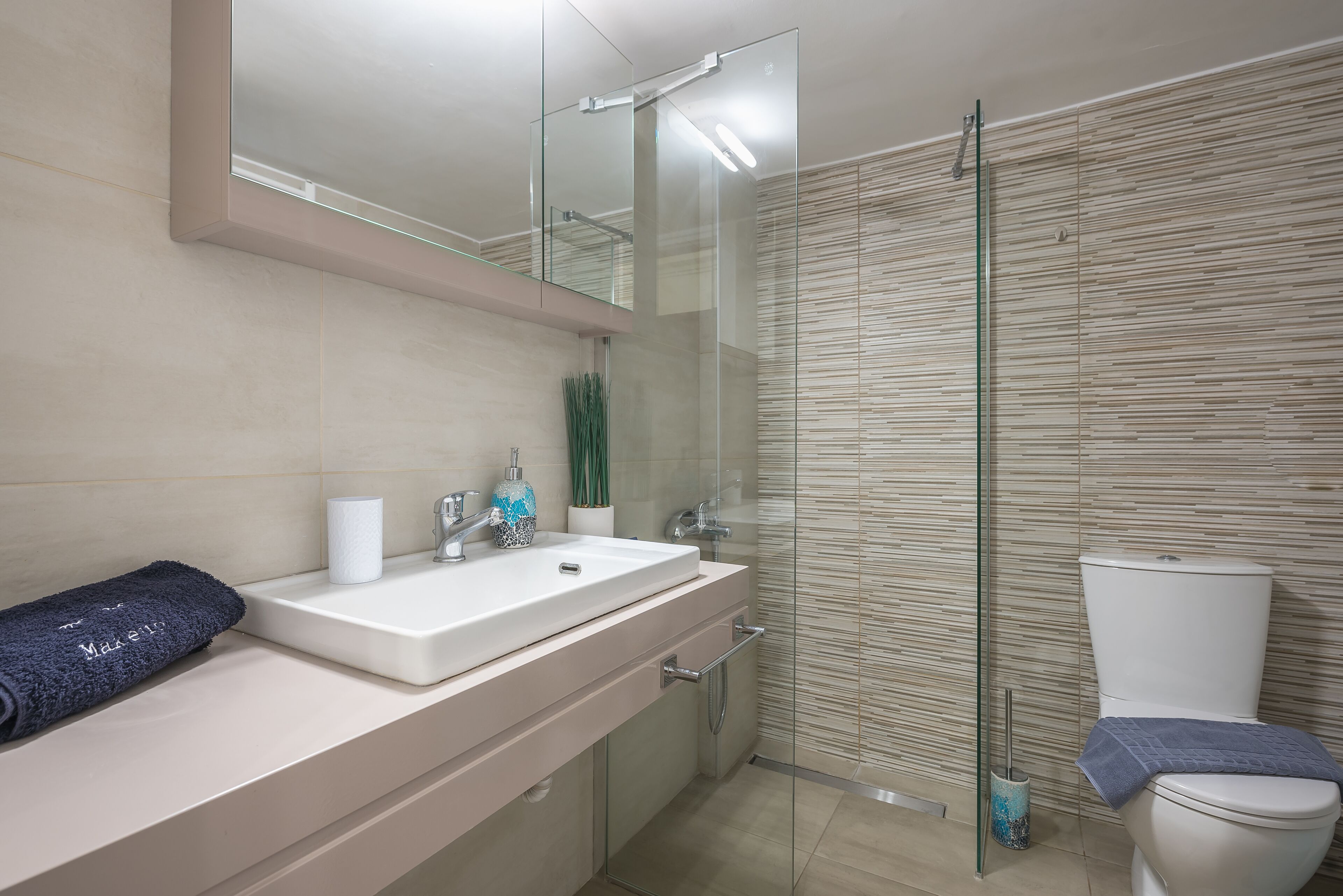 City appartement | Badkamer | Een douche, een haardroger, handdoeken, zeep