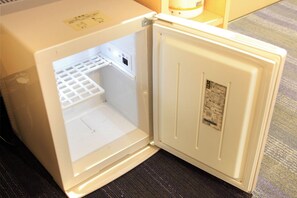 The refrigerator features a freezer compartment on top and a control panel.