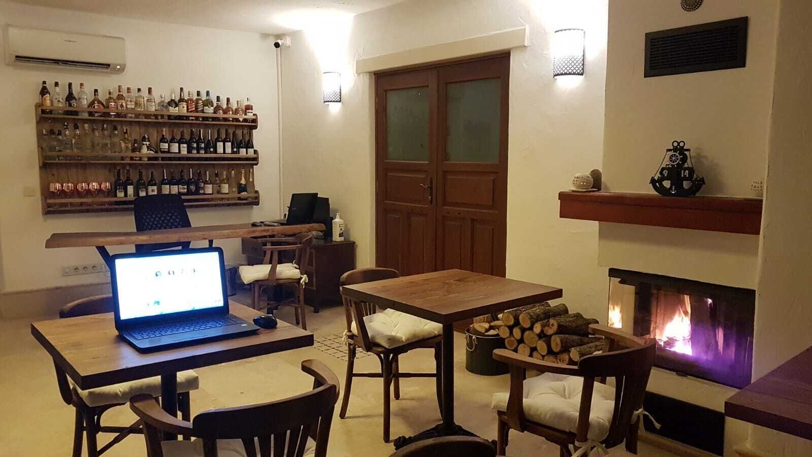Una stanza accogliente con camino, mobili in legno e un laptop su un tavolo.
