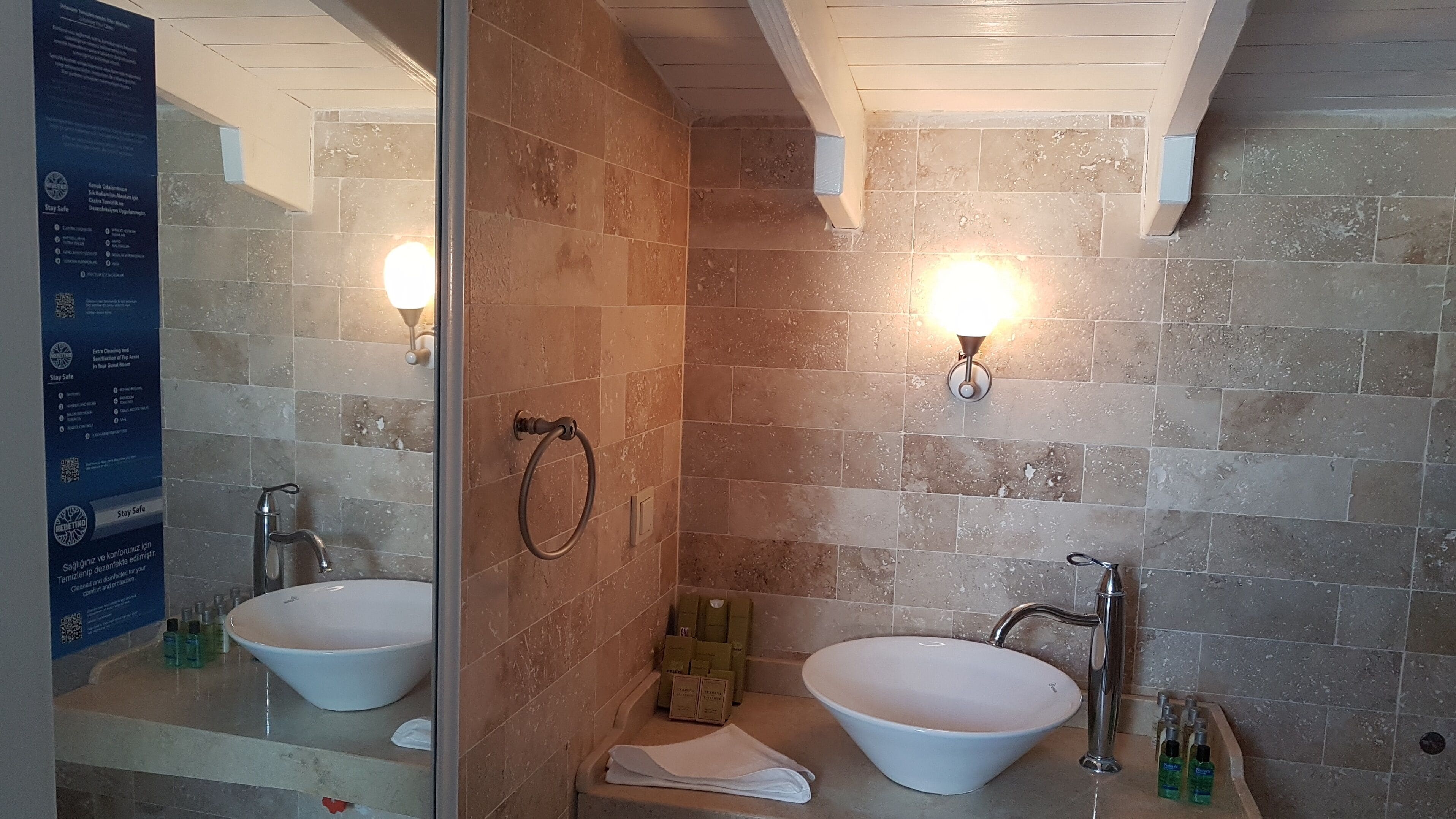 Een badkamer met twee wastafels, een douchecabine van glas en een handdoekrek.